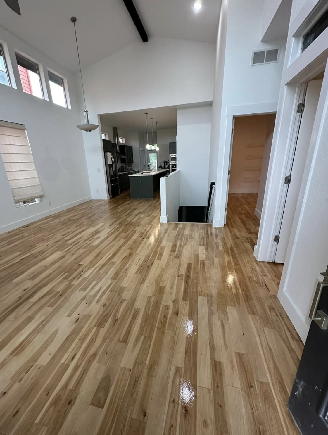 Freshly installed hardwood flooring in a bright vaulted living room